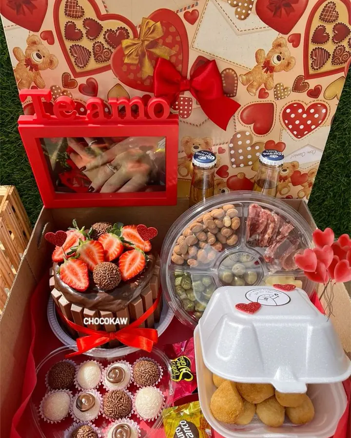 Cesta de celebração com bolo, brigadeiros, petiscos, bebidas, porta-retrato e flores