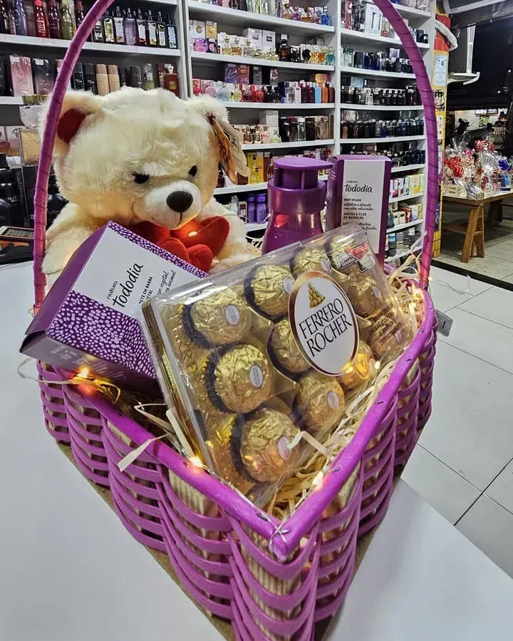 Cesta lilás com ursinho, chocolates Ferrero Rocher e perfumaria.